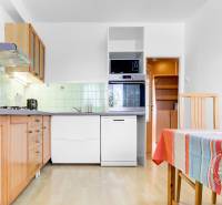 A bright kitchen in a 3-room apartment with wooden cabinets and a wooden decor floor.