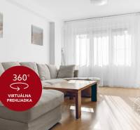 A bright living room with a comfortable sofa and a wooden decor floor in a 3-room apartment.