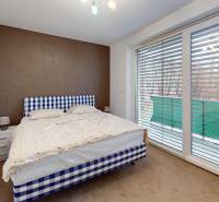 Bedroom in a 4-room apartment with a double bed and sliding doors to the balcony.