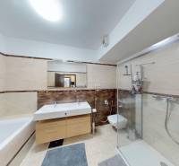 A bathroom in a 4-room apartment with a bathtub, shower, and two sinks.