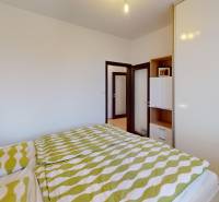 Bedroom in a 4-room apartment with a bed, green bedding, and a built-in wardrobe.