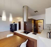 The kitchen of a 4-room apartment with a wooden decor floor and a dining table.