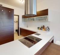 A kitchen with a wood-patterned floor and a modern cooktop in a 4-room apartment.
