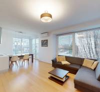 Living room with a corner sofa, dining table, and wooden decor flooring in a 4-room apartment.