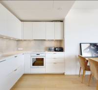 A kitchen in a 3-room apartment with white cabinets, floor with wood decor.