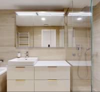 A stylish bathroom in a 3-room apartment with a bathtub, shower, and storage space.