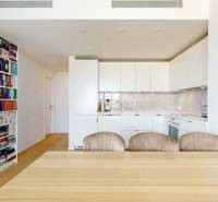 A kitchen in a 3-room apartment with built-in appliances, a dining table, and a bookshelf.