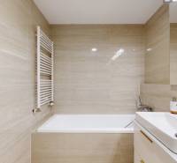 Bathroom with a bathtub, sink, and mirror in a 3-room apartment.