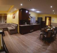 Kitchen and living room Hotels and guesthouses with a corner sofa and wooden decor flooring.