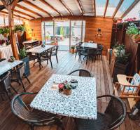 In hotels and guesthouses with wooden decor flooring, there are tables, chairs, and flowers.