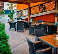 Outdoor seating in Poprad, surrounded by greenery, hotels and guesthouses.