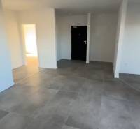 Interior of a 3-room apartment with large tiles and white walls.