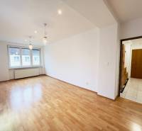 A room in a 2-room apartment with a wooden decor floor, lighting fixtures, and a built-in window.