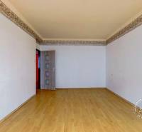 A room in a 3-room apartment with a wooden decor floor and white walls.