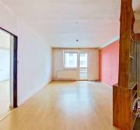 Spacious interior of a 3-room apartment with wood-patterned flooring and a balcony.