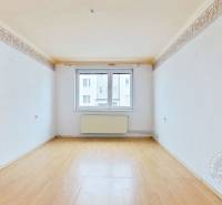 A room with white walls and a wooden decor floor in a 3-room apartment.