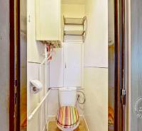 A toilet with a colored seat, piping, and storage space in a 3-room apartment.