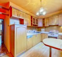 A kitchen in a 3-room apartment with built-in appliances and a wooden decor floor.