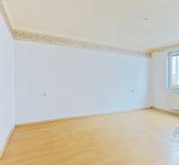 An empty room with a wooden decor floor in a 3-room apartment.
