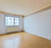 A spacious room in a 3-room apartment with a wooden decor floor and a large window.