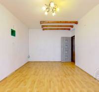 Living room in a three-room apartment with a wooden decor floor and a light chandelier.