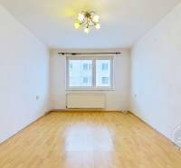 A room with a wood-patterned floor and a window in a 3-room apartment.