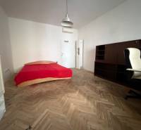 A room with a bed, a desk, and a floor with a wooden decor in a 3-room apartment.