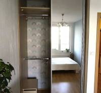 Built-in wardrobe with a mirror, next to the room with a bed in a 2-room apartment.