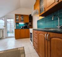 A kitchen with wooden cabinets and green tiles in a family house.
