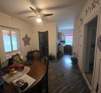 The dining room of a family house with a ceiling fan and decorative wall decorations.