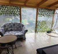 A family house with a spacious terrace, a comfortable couch, and a swing in the town of Hont.