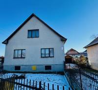 A family house on Veľké Bielice Street in Partizánske with a fenced garden, snowy yard.