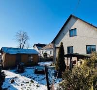 Pitched roof, adjacent shed, and snow-covered garden at a family house in Partizánske, in Veľké Bielice.