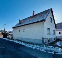 A family house on Veľké Bielice Street in Partizánske, next to the road, with a snow-covered garden.