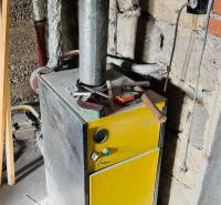 Boilers in a family house, with tools on top, in an unfinished room.