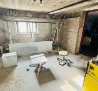 A basement space in a family house with simple furniture and a window.