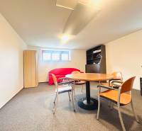 Office in a family house with windows, a table, chairs, a sofa, and a wardrobe.