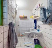 A bathroom in a family house with light tiles and colorful decorations.