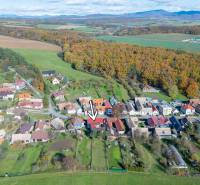 An aerial view of Lieskovec with its wooded surroundings and rural family houses.