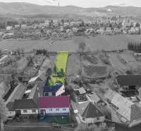 Aerial view of Lieskovec with a family house and a long plot of land in the foreground.