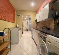 A kitchen in a 5 or more room apartment with white cabinets and tiles, appliances on both sides.