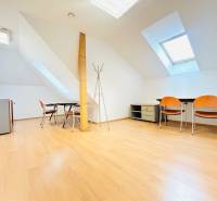 Offices with wood-patterned flooring, skylights, desks, and chairs.
