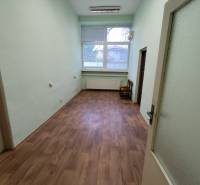 Offices with wood-patterned flooring and a large window available for rent.