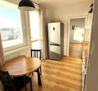 A kitchen with a wooden decor floor and a dining table in a 3-room apartment.