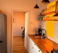 A kitchen in a 3-room apartment with light furniture and a wooden decor floor.
