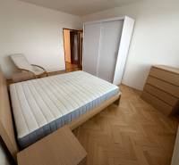 Bedroom with a bed and wooden decor flooring in a 3-room apartment.
