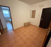 The entrance hall of a 3-room apartment with ceramic tiles, a coat rack, and a view of the room.
