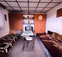 Interior of a cabin with beds, a table, cabinets, and decorations.
