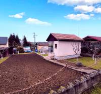 The exterior of the cottage in Partizánske with a landscaped garden, lawn, and flower bed.