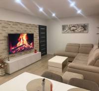 Living room in a 3-room apartment with a corner sofa and a wooden decor floor.